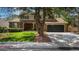 Lovely two-story home with a brick facade, mature trees, well manicured lawn and black garage doors at 7655 S Ogden Way, Centennial, CO 80122