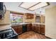 Traditional kitchen with wood cabinets, granite countertops, black appliances, and a window above sink at 7655 S Ogden Way, Centennial, CO 80122