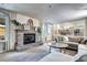 Cozy living room features a brick fireplace, neutral colors, and an open floor plan into the dining area at 8581 W Hinsdale Pl, Littleton, CO 80128