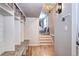 Well-organized mudroom with built-in shelving, bench, and easy access to the entrance and stairs at 8581 W Hinsdale Pl, Littleton, CO 80128