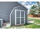 Backyard shed featuring double doors, gray siding, and white trim, great for storage at 8581 W Hinsdale Pl, Littleton, CO 80128