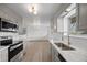 Updated kitchen with stainless appliances, light gray cabinetry, quartz countertop, and views to the adjacent room at 1002 Zang St, Golden, CO 80401