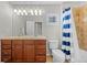 Bathroom with double sinks, a shower/tub combination, and blue and white striped shower curtain at 23101 Timber Spring Ln, Parker, CO 80138