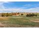 Picturesque golf course view with deer grazing, set against a backdrop of neighborhood homes under a bright sky at 23101 Timber Spring Ln, Parker, CO 80138