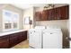 Laundry room featuring a washing machine, dryer, storage cabinets and a folding counter at 23101 Timber Spring Ln, Parker, CO 80138