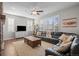 Comfortable living room with large windows, wood floors, plush seating, and modern ceiling fan at 23101 Timber Spring Ln, Parker, CO 80138