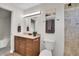 A well-lit bathroom featuring a tiled shower-tub and vanity at 9946 Harrison St, Thornton, CO 80229
