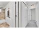Hallway featuring closet space and access to bathroom with tile shower at 9946 Harrison St, Thornton, CO 80229
