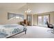 Bright bedroom featuring a ceiling fan, vaulted ceilings, neutral carpet and access to private balcony at 1348 Lawson Ave, Erie, CO 80516
