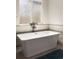Modern bathroom featuring a standalone tub with sleek fixtures and frosted glass window at 3427 S Cherry St, Denver, CO 80222