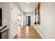Hallway with hardwood floors and neutral walls leading to a front door and other rooms at 3427 S Cherry St, Denver, CO 80222