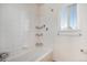 Neat bathroom features tile flooring, a shower-tub combo with tile walls, and a window bringing in natural light at 4697 Waldenwood Dr, Highlands Ranch, CO 80130