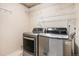 Laundry room equipped with modern washer and dryer units and wire shelving at 4697 Waldenwood Dr, Highlands Ranch, CO 80130