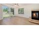 Living room with a fireplace, a ceiling fan, and large glass doors leading to a fenced backyard at 4697 Waldenwood Dr, Highlands Ranch, CO 80130