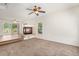 Open living room featuring neutral walls, a cozy fireplace, a ceiling fan, and large glass doors to the backyard at 4697 Waldenwood Dr, Highlands Ranch, CO 80130