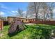 Backyard featuring a playhouse with slide, green lawn, and privacy fence at 1865 S Logan St, Denver, CO 80210