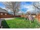 View of fenced backyard with green lawn, playhouse, and concrete patio at 1865 S Logan St, Denver, CO 80210