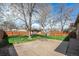 Spacious backyard with mature trees, a grassy lawn, concrete patio and wooden privacy fence at 1865 S Logan St, Denver, CO 80210