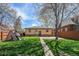 Well-maintained backyard featuring green lawn, a charming playhouse, and a concrete path to the home at 1865 S Logan St, Denver, CO 80210
