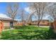 Spacious backyard with lush green grass, a brick house, and a playground set, perfect for outdoor enjoyment at 1865 S Logan St, Denver, CO 80210