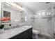 Bathroom featuring a vanity with granite countertop, a glass-enclosed shower, and tile flooring at 1865 S Logan St, Denver, CO 80210