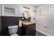 Updated bathroom features wainscoting, an oval mirror, and shower over tub at 1865 S Logan St, Denver, CO 80210