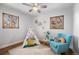 Bright bedroom features hardwood floors, sunny windows, a fun teepee, and cheerful decor at 1865 S Logan St, Denver, CO 80210