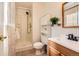 Functional bathroom with a shower, toilet, vanity, and built-in shelving for storage at 8813 W Arbor Ave, Littleton, CO 80123