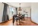 Bright dining room with hardwood floors, chandelier lighting, a large window, and stylish decor at 8813 W Arbor Ave, Littleton, CO 80123