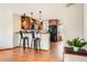 Well-lit kitchen with stainless steel appliances, breakfast bar, and hardwood floors, perfect for cooking and entertaining at 8813 W Arbor Ave, Littleton, CO 80123