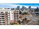 Aerial view of a condo complex with multiple stories and balconies overlooking a city skyline at 4875 S Monaco St # 103, Denver, CO 80237