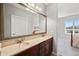 Bathroom with double sinks, granite countertops and a large mirror at 4875 S Monaco St # 103, Denver, CO 80237