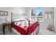 Bright bedroom with a window view, featuring a patterned bedspread and unique decor at 4875 S Monaco St # 103, Denver, CO 80237