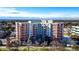 Large brick apartment building with balconies surrounded by trees and snow covered ground at 4875 S Monaco St # 103, Denver, CO 80237