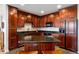 Modern kitchen featuring dark wood cabinets, granite countertops, and a central island with seating at 4875 S Monaco St # 103, Denver, CO 80237