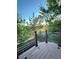 Cozy deck with wood flooring and curved metal railing, surrounded by lush green trees at 23760 Broadmoor Dr, Parker, CO 80138