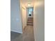 Hallway with carpeted floors and a view of the staircase and kitchen in the background at 23760 Broadmoor Dr, Parker, CO 80138