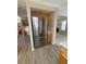 Stainless steel refrigerator flanked by cabinets, with a view of the stairs and living room at 23760 Broadmoor Dr, Parker, CO 80138