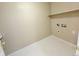 An unfinished laundry room area with vinyl flooring, shelving, and utility hookups at 23760 Broadmoor Dr, Parker, CO 80138