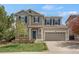 Charming two-story home featuring a manicured lawn, inviting blue door, and an attached two-car garage at 1558 Wandering Way, Castle Rock, CO 80109