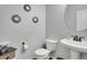 Half bathroom with pedestal sink, decorative mirrors, and hardwood floors at 1558 Wandering Way, Castle Rock, CO 80109