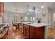 Open-concept kitchen with a large island, hardwood floors, and a view of the living room and fireplace at 1558 Wandering Way, Castle Rock, CO 80109