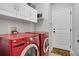 Functional laundry room with LG front-loading washer and dryer, storage cabinets, and a door to the exterior at 1558 Wandering Way, Castle Rock, CO 80109