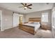Main bedroom with a tray ceiling, ceiling fan, and sliding barn door to bathroom at 1558 Wandering Way, Castle Rock, CO 80109