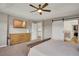 Bright main bedroom featuring a ceiling fan, dresser, walk-in closet, and ensuite bathroom at 1558 Wandering Way, Castle Rock, CO 80109
