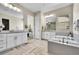 Bright bathroom featuring herring bone floors, soaker tub, double vanity, walk in closet, and large mirrors at 8661 S De Gaulle Ct, Aurora, CO 80016