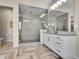 Bathroom featuring herring bone floors, double shower heads in a glass enclosed shower and double vanity at 8661 S De Gaulle Ct, Aurora, CO 80016