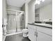 Modern bathroom with tiled shower and flooring, plus white vanity at 8661 S De Gaulle Ct, Aurora, CO 80016