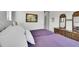 Comfortable bedroom with a dresser, hardwood floors and white bedding at 8661 S De Gaulle Ct, Aurora, CO 80016