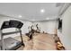 Exercise room featuring treadmill, fan bike, wood flooring, and tv at 8661 S De Gaulle Ct, Aurora, CO 80016